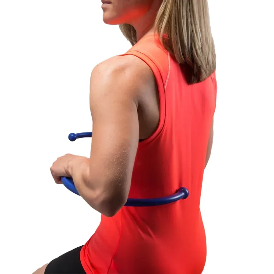 A woman holding the blue Backnobber II across her lower back, its knob pressing beside her spine