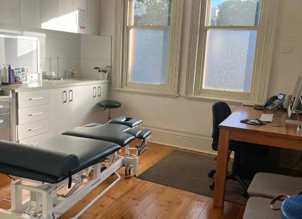A second chiropractic treatment room with an adjusting table and window