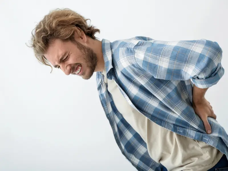 Young man with severe back pain in need of Chiropractor Melbourne