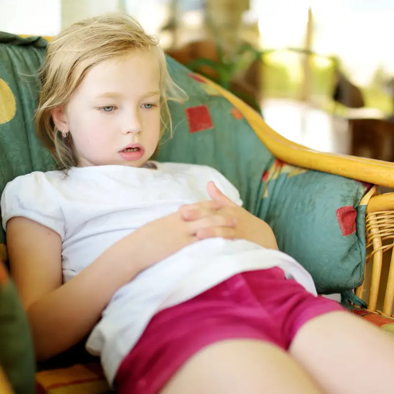 Young girl lying down, appearing fatigued or in discomfort from growing pains